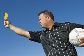 Fototapeta premium soccer referee holding yellow card portrait