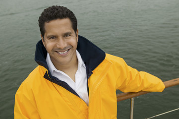 man wearing yellow anoraks on yacht (portrait) (elevated view)