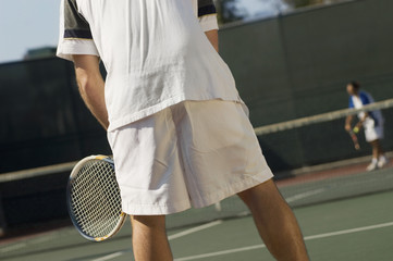 tennis player on court waiting for serve back view