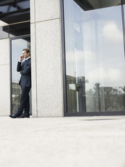 Fototapeta premium businessman using mobile phone outside office building