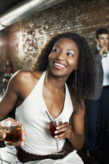 woman holding cocktail sitting in bar