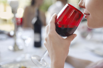 young woman drinking from wineglass close-up side view