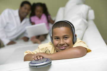 boy on sofa listening to portable cd player portrait