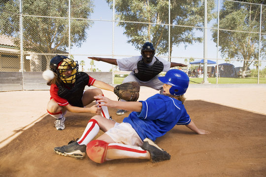 softball player slideing into home plate