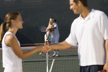 tennis players shaking hands at net side view