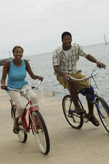 Obraz premium couple cycling on beach smiling