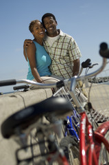 Fototapeta na wymiar couple with bicycles embracing on wall (portrait)