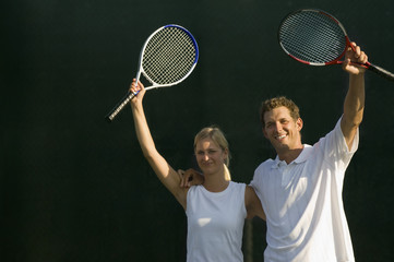 Tennis Partners Raising Rackets in Victory