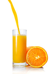 orange juice poring into glass isolated on white