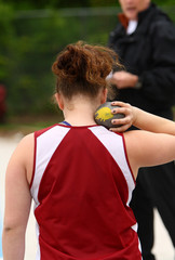 Female athlete about to throw a shotput.