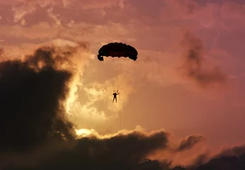 Photo sur Plexiglas Sports aériens Parachutist against a colorful sunset and clouds.