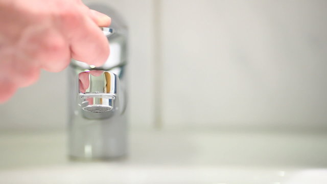 Hand closing a running faucet - 1920x1080- high quality