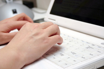 A woman working on white laptop