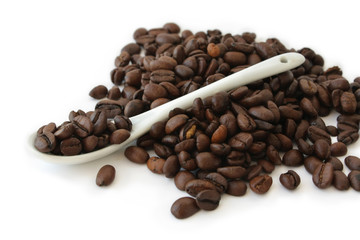 Coffee beans and spoon on a white background