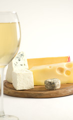 Glass of white wine and cheese on a cheese board