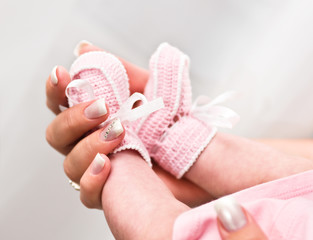 Newborn baby feet in mother hand