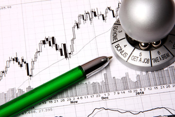 Financial chart with a souvenir saying "bonus" and a green pen