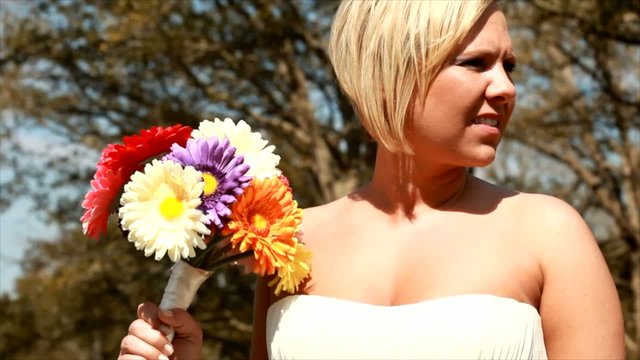 Lovely bride holding a colorful bouquet of flowers.
