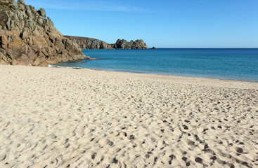 Fototapeta na wymiar Porthcurno sandy beach and Logan rock in Cornwall UK.