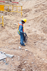 building worker at the building sitecarrying an electrical cable