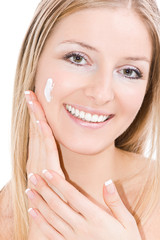White caucasian blonde woman creaming face