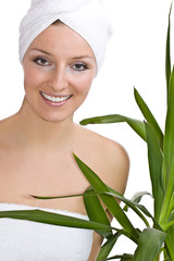 Caucasian woman with towel on head and green plant