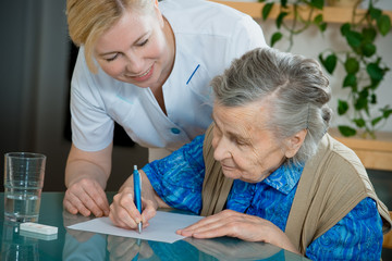 Assisting a senior woman by nurse at home.
