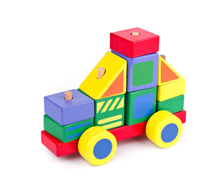 Toy car made of colorful wooden blocks on white background