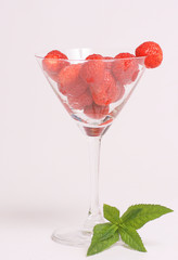 Strawberry and mint around a martini glass
