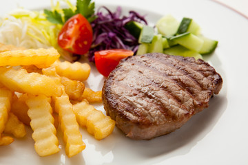 Grilled steak with chips and vegetables