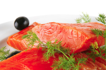 pink smoked salmon on white plate with olives