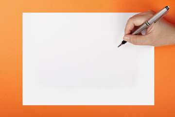 A woman's hand with a pen on a piece of paper