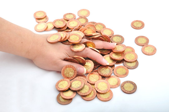 Hand in pile of coins