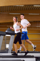 Fototapeta na wymiar attractive couple is running on the treadmill