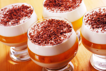 Multilayer gelatin dessert with cream and jelly in glasses