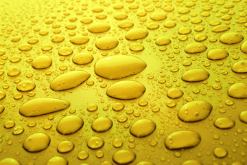 Yellow water drops background with big and small drops