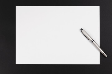 A paper and pen on a black background