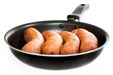 sausages in frying pan isolated on white background