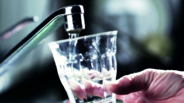 Person filling glass of water