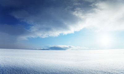 field of snow and cloudy sky