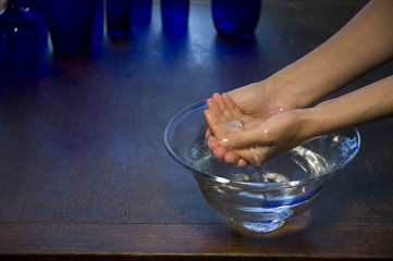 Two hands in a glass bowl of water