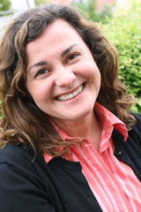 Woman, forty years old, brown curled hair, smiling