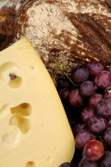 close-up with bread, cheese and red grapes