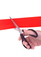 Woman hand with scissors cutting red ribbon