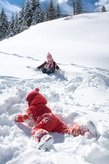 Fototapeta na wymiar two little girls playing on the snow
