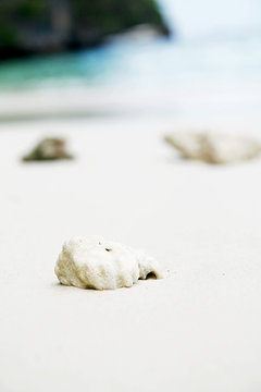 small rock on white sand beach