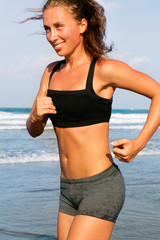 Photo of sports girl runs along the beach