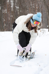 Female snowboarder adjusting bindings