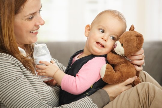 Happy mum and baby with teddy bear