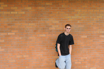 Student standing in front of brick wall